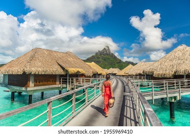 Tahiti luxury hotel honeymoon travel vacation tourist woman walking at luxury resort in overwater bungalows villas. View of Mount Otemanu, Bora Bora, French Polynesia
