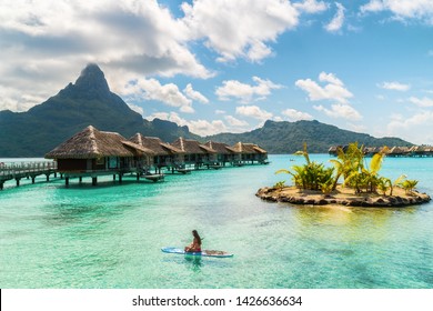 Tahiti luxury resort hotel in Bora Bora ,French Polynesia. Paddleboard leisure activity SUP paddle woman on active vacation in Tahiti, French Polynesia. Mount Otemanu summer holiday.