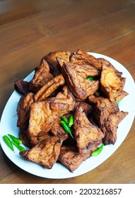 Tahu Bacem Is Tofu Cooked With Seasoning Garlic, Shallots, Coriander, Bay Leaves, Palm Sugar, Soy Sauce. Sweet And Tasty. Served With Raw Green Chilli. Placed In White Plate On Table. High Angle View