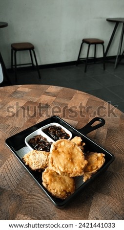 tahu walik with soy sauce. Dried tofu is processed into a delicious snack that is often available in modern cafes. portrait. indoors