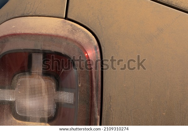 Tail light and\
background of a dusty texture in a car, completely dirty with dirt\
and mud and dust stuck to\
it