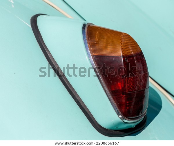 The tail\
light of a vintage retro car. Retro car brake light. The rear\
fender of a vintage car is\
pistachio-colored.