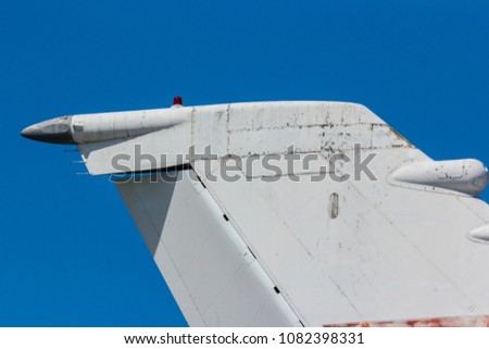 Tail of a plane with old abandoned plane in background