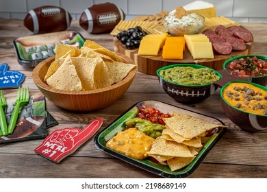 Tailgating Football Party Food Display With Tortilla Chips, Guacamole, Salsa, And Queso Dips And Meat, Cheese And Cracker Tray Ready For Game Day Party