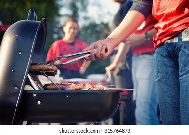 Tailgating: Man Grilling Sausages And Other Food For Tailgate Party