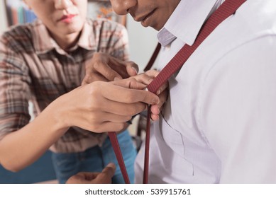 Tailor Assisting Young Man Getting Dressed  
