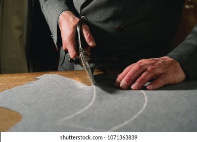 A tailor cutting a cloth according to the tradition of tailors. The dressmaker uses perfectly needle and thread to sew traditional concept, sewing