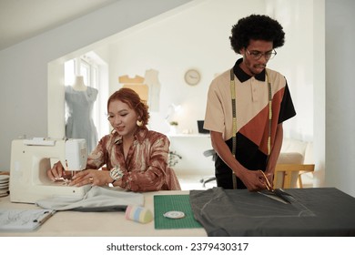 Tailor cutting fabric when seamstress sewing together pieces - Powered by Shutterstock