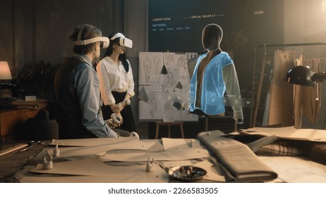 Tailor and female customer put VR goggles in atelier workshop. 3D hologram of jacket pattern. Virtual interface menu of program for designing and modeling clothes. Technologies of augmented reality. - Powered by Shutterstock