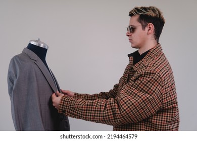 Tailor Finishing A Suit. Fashion Designer Placing Garment On A Mannequin. Young Fashion Design Student Making A Suit. High Quality Photo