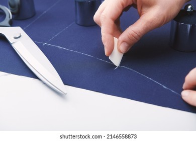 Tailor makes markings with chalk on the fabric. Clothes sewing. Tailoring. Close up view