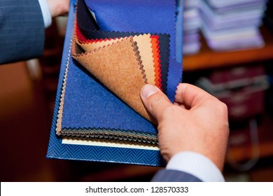 Tailor. Man Searching Through Fabrics For A Suit