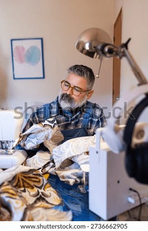 Tailor man working on fabric with sewing machine