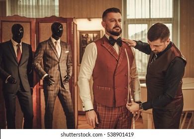 Tailor measuring client for custom made suit tailoring