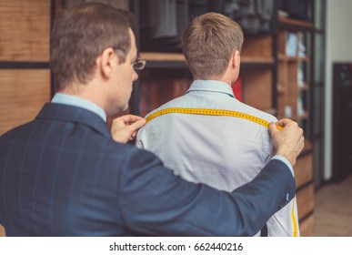 Tailor Measuring The Customer In Studio