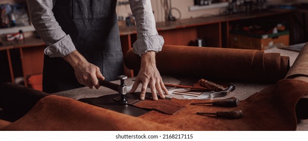 Tailor processing hammers seam on leather goods, banner Handmade craftsman.