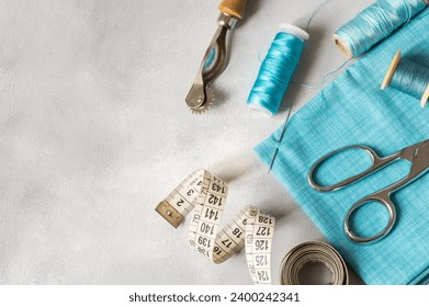 Tailor sewing accessories, craft concept background, scissors, tracing wheel, measure, threads - Powered by Shutterstock