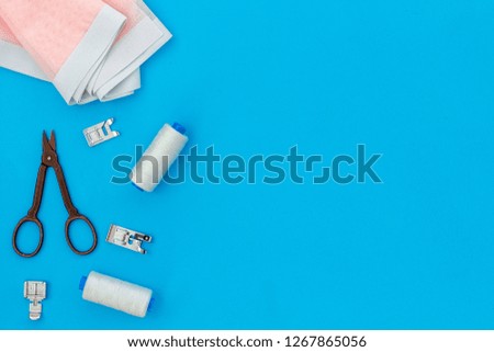 Tailor shop with thread, scissors, fabric. Sewing as hobby. Blue background top view mockup