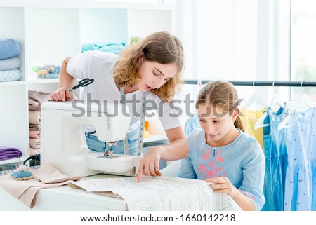 Tailor is teaching student at workshop