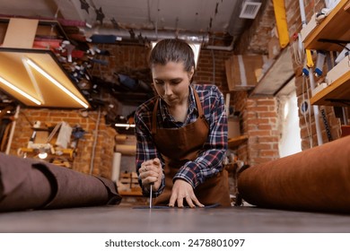 Tailor woman shoemaker cutting brown leather patterns in atelier workshop. - Powered by Shutterstock