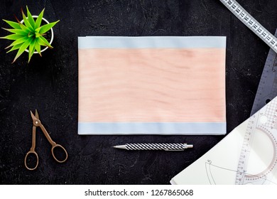 Tailor work place with thread, scissors, fabric. Sewing as hobby. Black background top view space for text