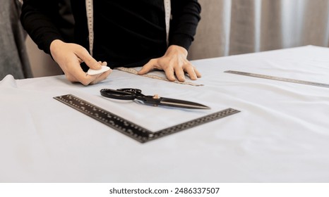 Tailor working at table in workshop. tailor designer's hands with chalk