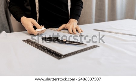 Tailor working at table in workshop. tailor designer's hands with chalk