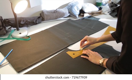 Tailor.Hands notch tailor tailor's scissors cloth. Female tailor stitching material at workplace. Preparing fabric for clothes making. Tailoring, garment industry, designer workshop concept. - Powered by Shutterstock