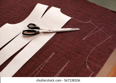 Tailoring. Clothing sewing fabric. Shoeupper dress patterns. Cut model of tissue with tailoring scissors. Sewing clothes knitwear. Drawing paper circled in chalk.