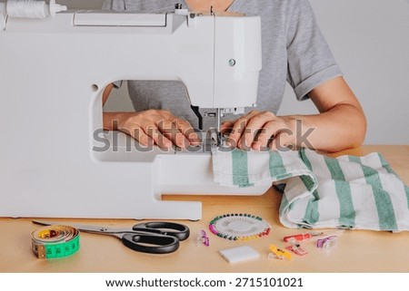 A Tailor's Craft: Operating a Sewing Machine with Various Tools and Materials for Fabric Creation and Modification
