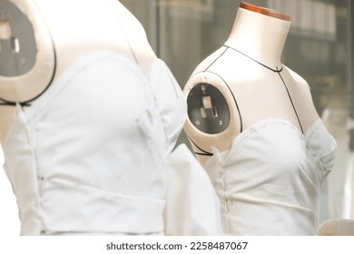 Tailor's textile female mannequin with black lines covered with canvas fabric pattern and draping for dressmakers working and designing new fashion collections in an atelier tailor workshop. - Shutterstock ID 2258487067