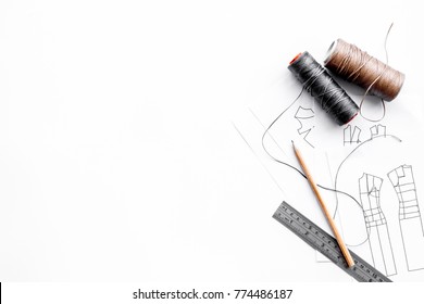 Tailor's work desk. Pattern of clothing and tools on white background top view copyspace