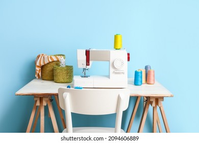 Tailor's workplace with sewing machine and threads near blue wall - Powered by Shutterstock