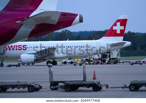 Tails of parked European airplanes at Zürich\
Airport on a cloudy late summer evening. Photo taken September 9th,\
2021, Zurich,\
Switzerland.