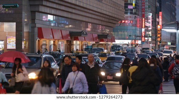 Taipei, Taiwan- 26 December 2018: People cross the\
road in Taipei city  at\
night
