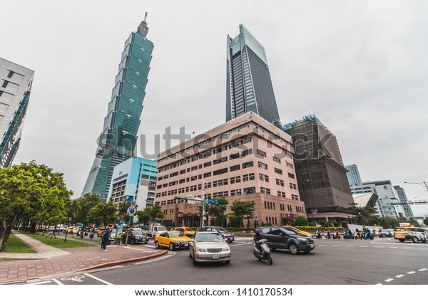 Taipei, Taiwan - April, 2019: Taipei 101\
Skyscraper photographed from a busy intersection along Xinyi road\
with cars passing\
through