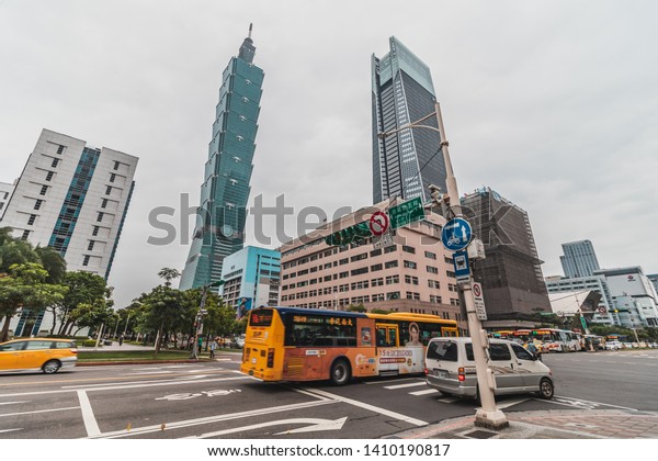Taipei, Taiwan - April, 2019: Taipei 101 Tower\
photographed from a busy intersection along the Xinyi Road with\
public passing through the\
crossroad