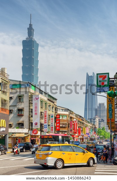 Taipei, Taiwan - April 25, 2019: Awesome view\
of Songren Road on sunny day. Taipei 101 (Taipei World Financial\
Center) and other skyscrapers are visible on blue sky background.\
Scenic cityscape.