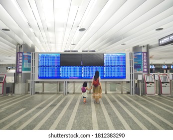 Taipei, Taiwan - August 2, 2020: A Mother Holding Hands With A Little Girl At The Taoyuan Airport MRT, Looking At The Flight Schedule Screen During COVID-19 Pandemic. Almost All Flights Are Cancelled.