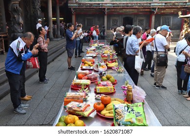 TAIPEI, TAIWAN - DECEMBER 4, 2018: People Leave Food Offerings At A Table Of Longshan Temple In Wanhua District Of Taipei City, Taiwan. It Is A Chinese Folk Religion Landmark.