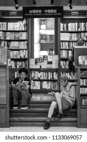 Taipei, Taiwan - July 11, 2018: Two Shoppers Sit And Peruse Books At A Local Bookstore