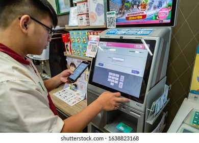 Taipei / Taiwan - June 16 2019: A Seven Eleven Officer Buys High Speed Train Ticket From NEC Ticket Kiosk