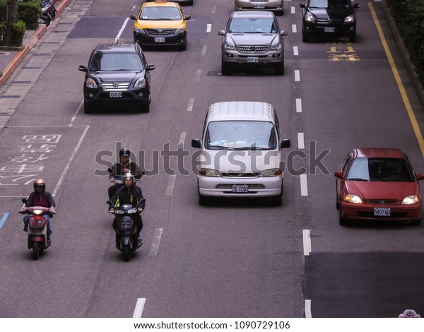 Taipei,Taiwan-April 16,2018:Top view of cars,\
motorcycles, and taxi  drive forward on the asphalt road in the\
same direction.Car,motorcycles, and taxi are convenient means of\
transportation in\
city.