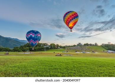 Taitung, Taiwan - August 29, 2021: Various Shape Balloons With Beautiful Sunrise And Green Grass At Luye Highland, Taiwan International Balloon Festival