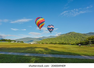 Taitung, Taiwan - August 29, 2021: Various Shape Balloons With Beautiful Sunrise And Green Grass At Luye Highland, Taiwan International Balloon Festival