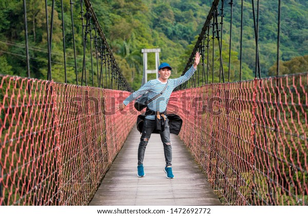 Taiwan, 07th July\
2019: tourists posing for pictures at Heavenly paradise  ( Tian\
Chang Di Jiu)  bridge at\
Taiwan