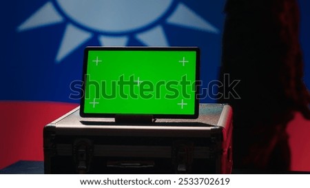 Taiwan army commander devising strategy to combat Chinese propaganda next to green screen tablet. Taiwanese freedom fighter walking in operation room in front of mockup device, camera A