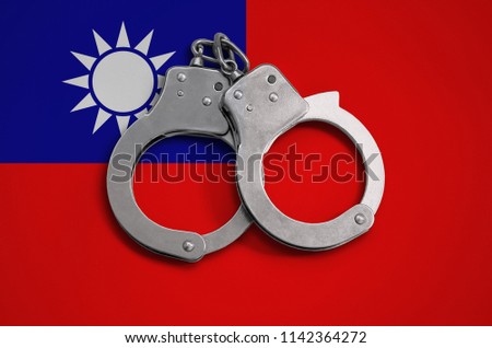 Taiwan flag  and police handcuffs. The concept of observance of the law in the country and protection from crime