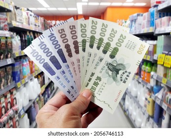 Taiwan, Kaohsiung, October 8, 2021: Five stimulus coupons. Taiwan issued stimulus coupons to boost the economy. Holding five-fold stimulus coupons, the background is deliberately blurred 