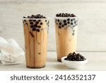 Taiwan Milk Tea with Boba Bubble Pearl on Plastic Disposable Cup, on Wooden Background